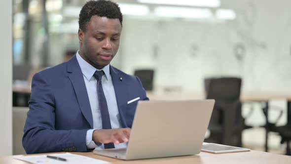 African Businessman Working on Laptop in Office