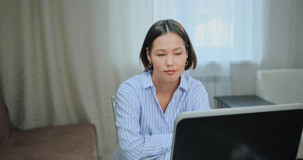 Concentrated Student Looks Into Laptop Display at Home