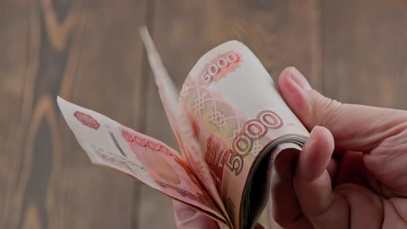 Caucasian Hand Checking Small Stack of Russian Ruble Banknotes