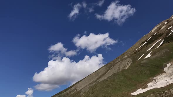 Time-lapse of clouds go over the mountainside. Clear blue sky, Nature of Georgia. Caucasus.