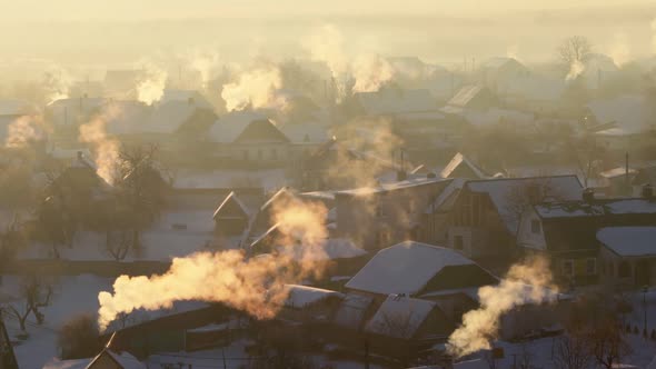 Orange Smoke Comes Out of the Chimneys in the Village on a Frosty Winter Morning