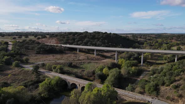 Aerial forward over old roman bridge and modern elevated road in background, Vila Formosa in Portuga