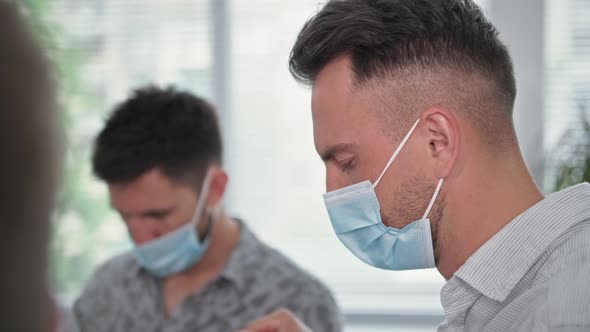 Worship in Quarantine Young Men and Women Wearing a Medical Mask Hold Hands and with Closed Eyes