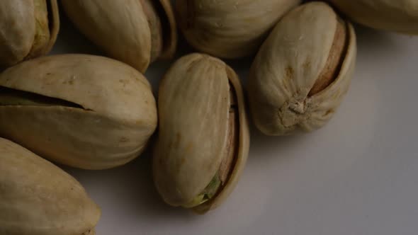 Cinematic, rotating shot of pistachios on a white surface - PISTACHIOS 009