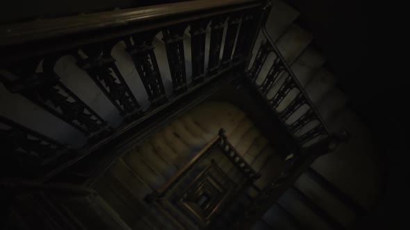 Tilt Into Overhead View of Old Wooden Staircase Leading in the Darkness