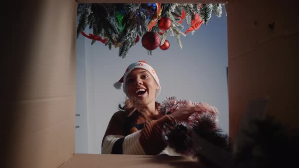 Festive Woman Taking Christmas Ornaments Out of Box
