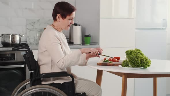 Mature Disabled Woman Cutting Vegetables in the Kitchen
