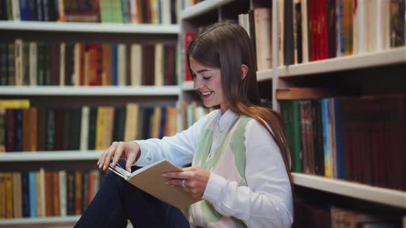 Student Reading Book on Library Floor