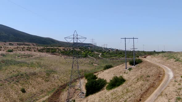 Aerial View of Electricity Transmission Pylon in Dry Valley Landscape