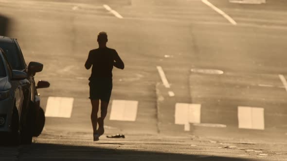 Athletic Mature Man Exercising Outdoors Running with Urban Street Background alt