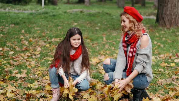 Mom and Daughter Throw Up Yellowed Leaves