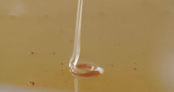 High angle shot of honey flowing into more honey. Honey dripping clockwise and counterclockwise. Mes