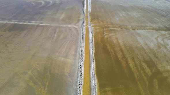 Abandoned Pier on Multicolored Lake Medicinal Clay Ungraded on Sunset, Air Drone View