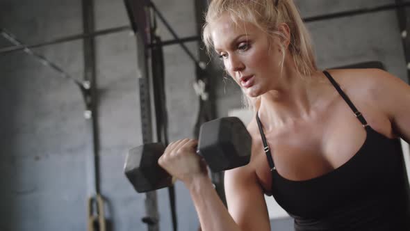 Woman Doing Dumbbell Bicep Curls in Gym