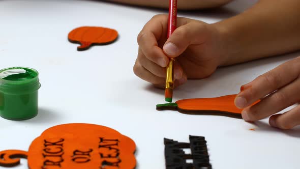 Children draw a pumpkin for Halloween. Needlework and preparation for the holiday.