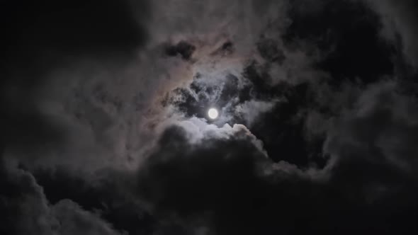 Full Moon Moving Between Clouds