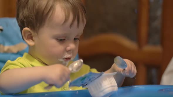 Little Boy in High Chair with Spoon