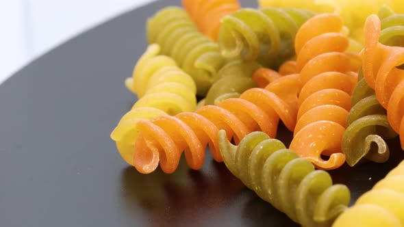 Close up view of fusilli, italian colored macaroni, macro shot in 4k. Rotating motion, view from abo