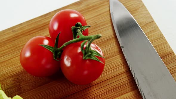 Vegetables and kitchen knife on chopping board