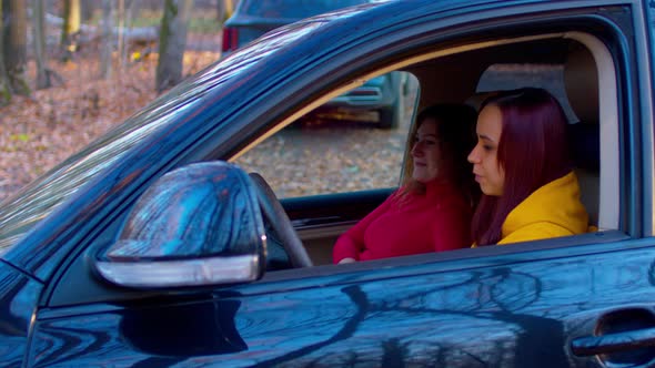 Young Women Sitting in Car and Talking