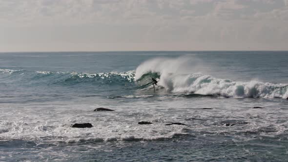 A surfer catches a nice wave off the coast of Australia and gets swallowed up by the whitewash befor