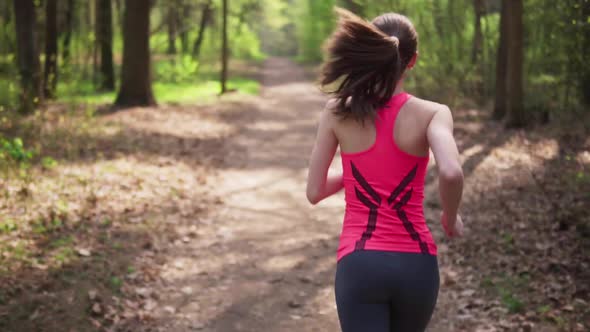 Fitness Woman Run in Spring Sunny Forest