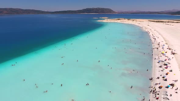 People Swim on Vacation in the White Sandy Beach of the Clear Tropical Turquoise Light Blue Sea