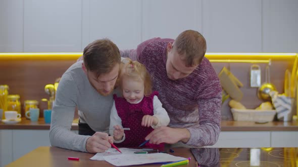 Cute Little Kid  With Gay Parents Drawing Indoors