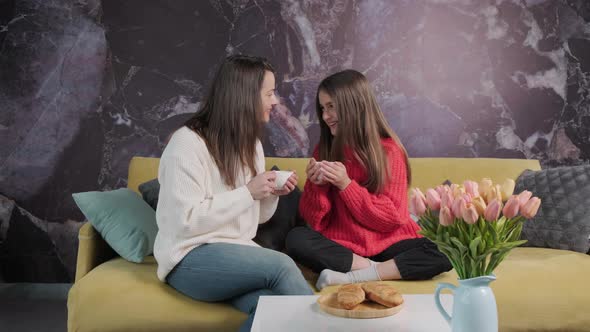 Mother and Daughter Drink Tea and Eat Croissants While Sitting and Talking