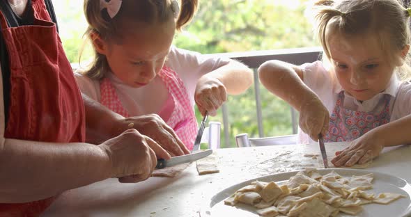 Close Up of Two Girls Cooking Pasta with Grandma