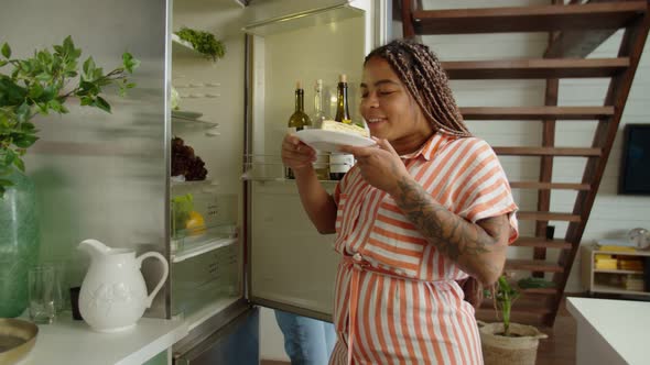 Asian Woman Preventing Black Female From Eating Unhealthy Food Indoors