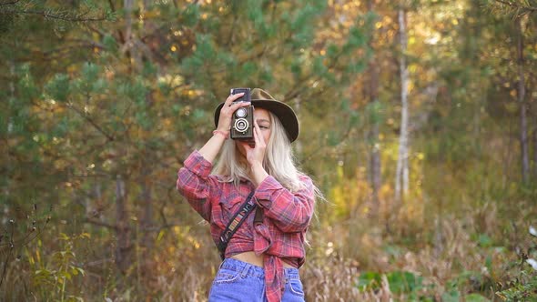 Portrait of Young Woman Taking Photo in the Forest.