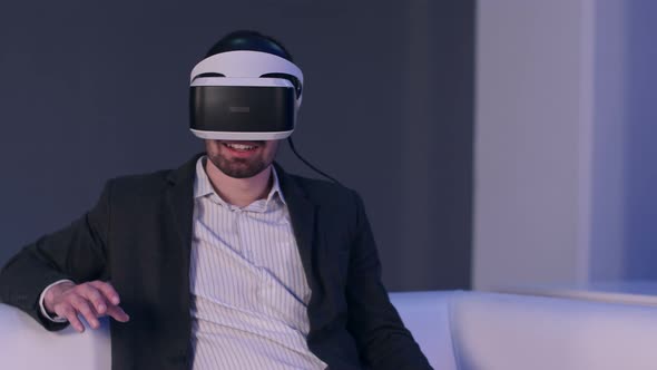 Relaxed Smiling Man in Suit Enjoying Virtual Reality Simulator