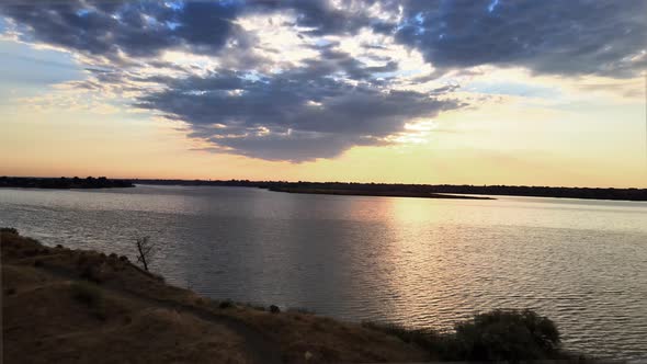 Picturesque panorama of the shore of Moses Lake at sunrise, a lone bird flies past, aerial