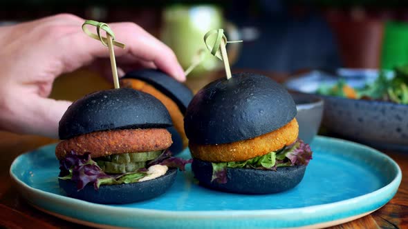 Closeup of Three Hamburgers with Different Toppings and Buns in Black