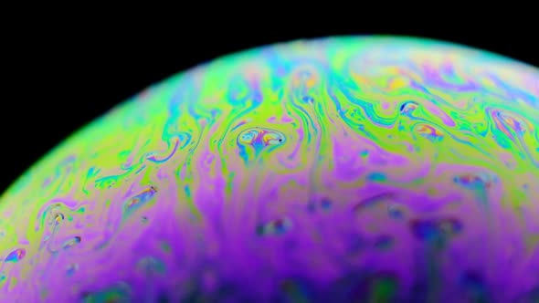 Rainbow Soap Bubble on a Dark Background. Close-up of Colorful Surface