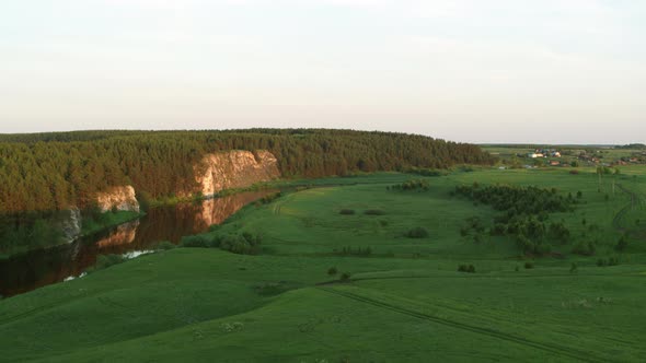 Aerial View of the River with a Rock and Forest on the Banks