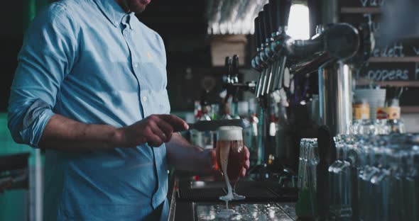 Barman crafting a beer in a urban modern bar