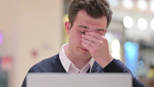 Stressed Young Businessman with Laptop Having Headache