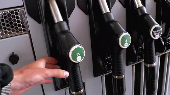 Man's Hand Taking the Fuel Nozzle at Gas Station