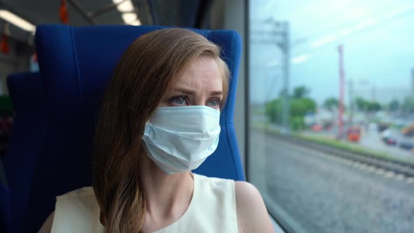 Young Woman in Mask in Moving Train Looking in Window