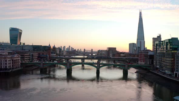 Cinematic rising dolly back aerial crane drone shot of sunrise over Thames river and central London