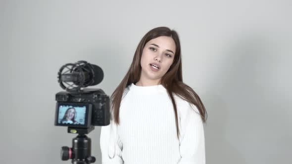 Girl Blogger Stands in Front of Camera, Broadcasts Live Straightens Hair Smiles