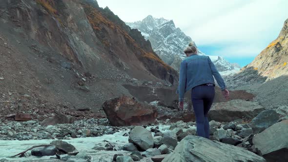 young tourist walks through mountainous area and looks at beautiful landscape.