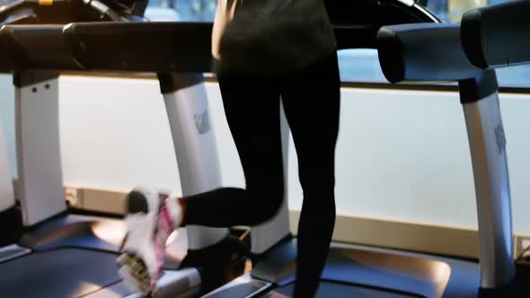 Rear view of fit woman exercising on treadmill