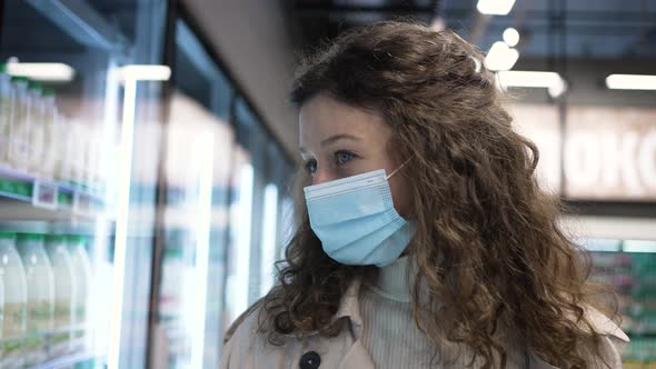 Woman in Mask Walks About Supermarket Looking for Products