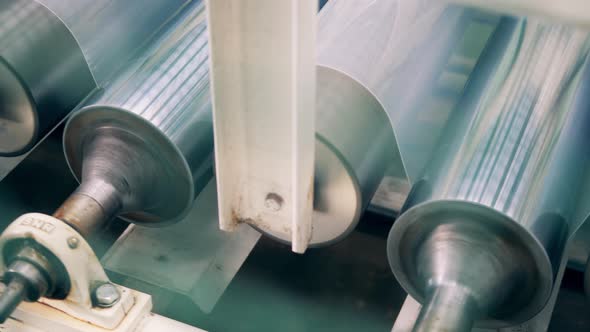 Close Up of Conveyor Rollers with Plastic Moving Along Them