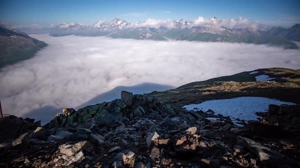 panoramic wide angle timelapse of a dynamic layer of morning fog moving in Oberengadin valley seen f