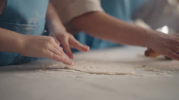 Little Girl and Her Mother are Cooking Cakes in Home in Weekend Woman is Rolling Out Dough