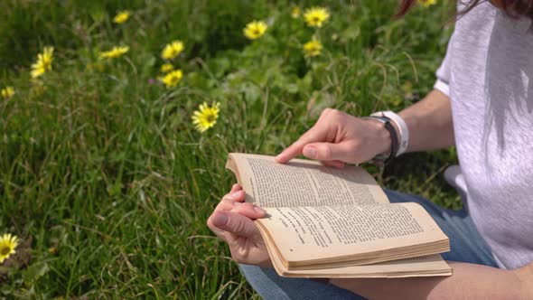 Reading a Book on Green Grass